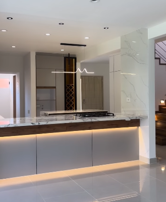 Cocina contemporánea con isla e iluminación cálida ejecutada por Proyecto EME